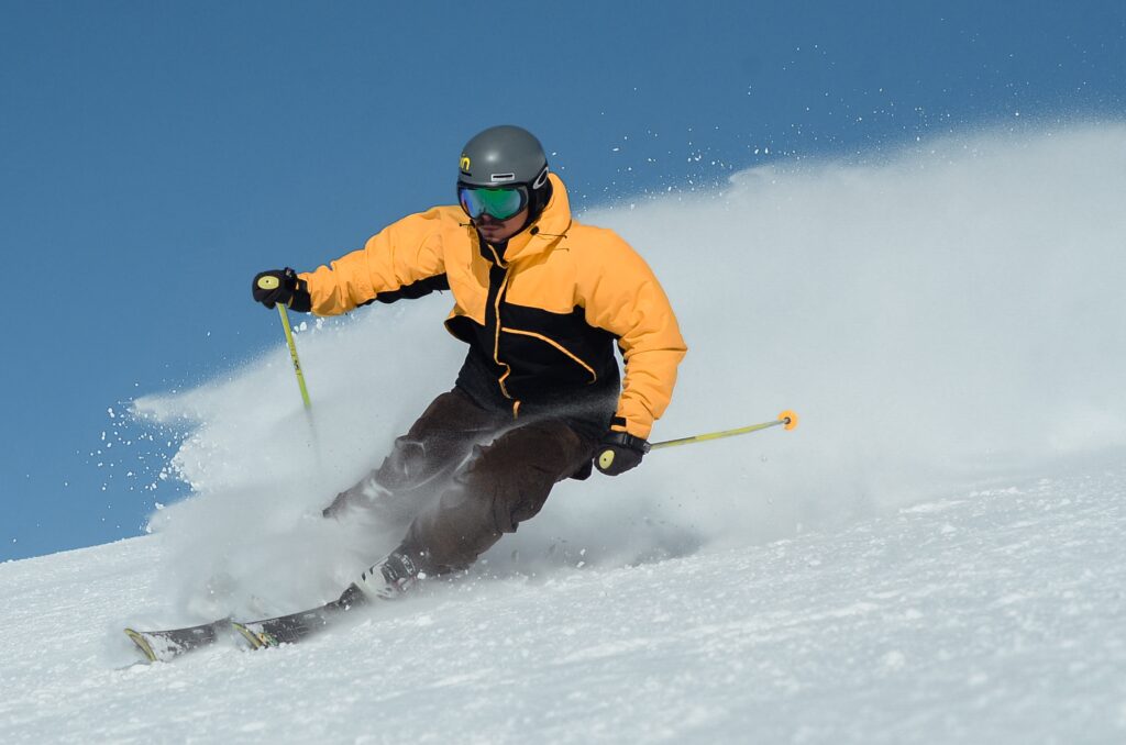 Ein Mann in einem Skianzug fährt die Piste runter